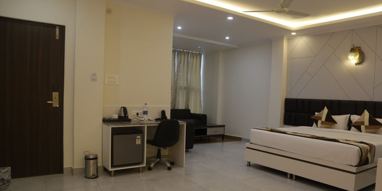 Une chambre d’hôtel moderne équipée d’un bureau, d’une chaise et d’un grand lit.
