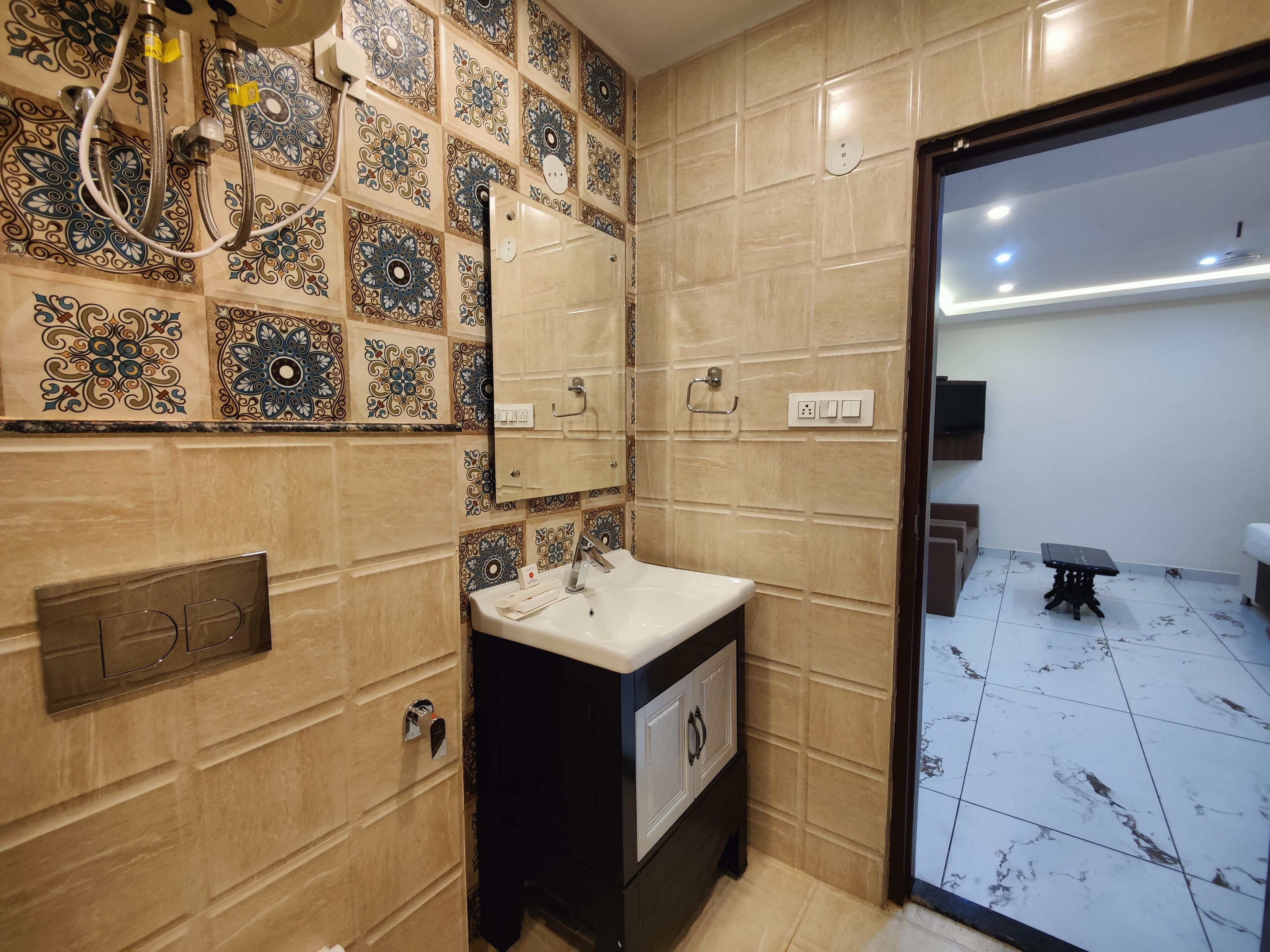 A bathroom with patterned tiles, a sink, and a mirror.