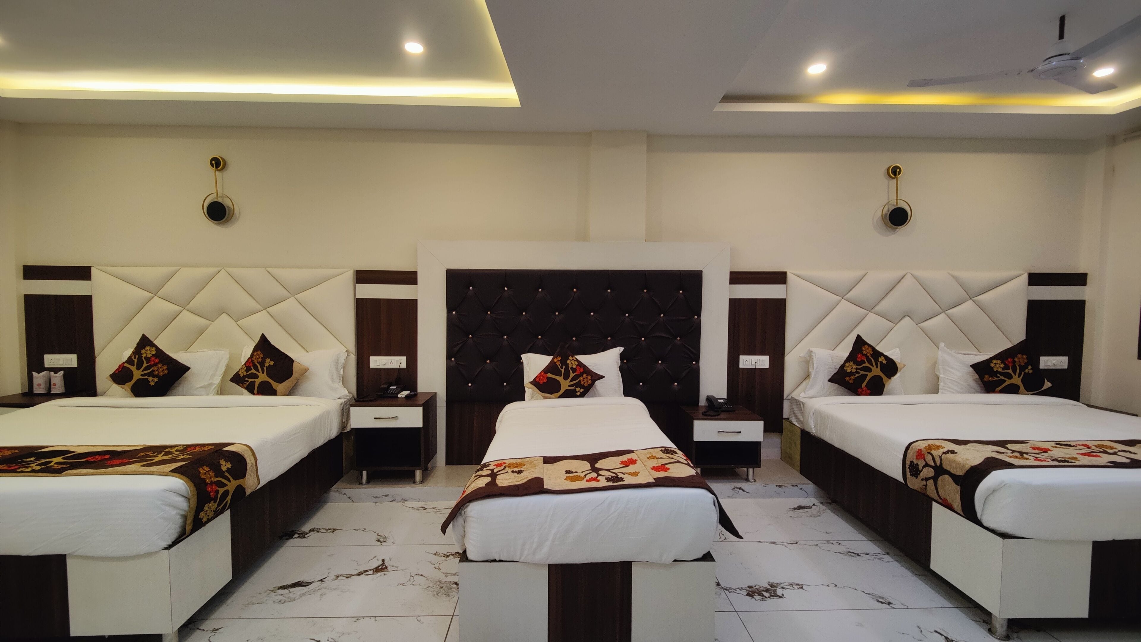 Een hotelkamer met twee bedden, een centraal hoofdeinde en een zithoek.