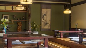 Una habitación tradicional japonesa con esteras de tatami, mesas de madera bajas y faroles de papel colgantes.