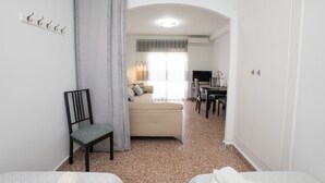 Une pièce comprenant un lit, une chaise, un canapé, une table à manger et un téléviseur.