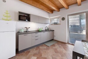 A kitchen with a microwave, kettle, and sink.