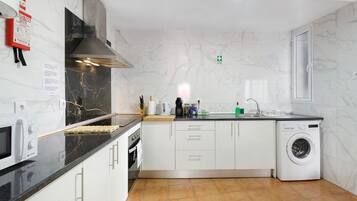 A modern kitchen with a built-in microwave, stove, and washing machine.