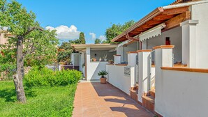 A pathway leading to a building with a tiled roof and white walls.