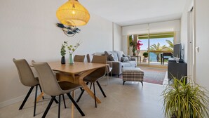 A modern living room with a dining area, a sofa, and a television. - Apartment 'Pelicano' with Sea View, Wi-Fi and Air Conditioning (Cambrils)
