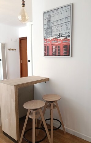 A small bar area with a wooden counter and two stools.