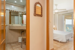 Een badkamer met een wastafel, spiegel en douche.