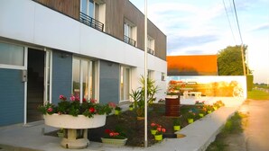 A modern building with a flat roof, large windows, and a balcony. - Apartment 'Les Racines De La Vie Rurale' with Wi-Fi and Air Conditioning (LEDRINGHEM)
