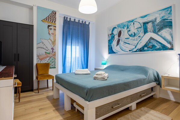 A bedroom with a bed, a chair, a wardrobe, and a painting on the wall. - Holiday Apartment "The View Of The Sea" near Beach with 2 Balconies & Wi-Fi (Capaci)