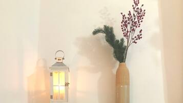 A fireplace with a brick surround, a decorative lantern, and a vase with red berries.