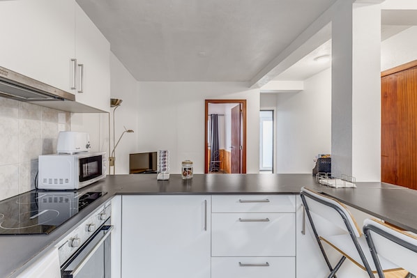 A modern kitchen with a microwave, oven, and cabinets.