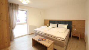 Une chambre à coucher avec un lit, une table de chevet et une fenêtre avec des rideaux.