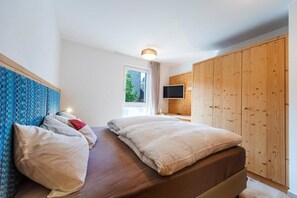 Une chambre à coucher avec un lit, une télévision et une armoire.