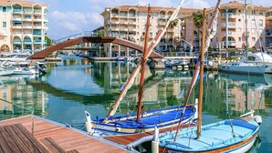A marina with wooden docks and sailboats, surrounded by multi-story buildings with balconies. - Port-fréjus, LE Consul, Appartement 2 Pièces Climatisé, Terrasse & Parking (Fréjus)