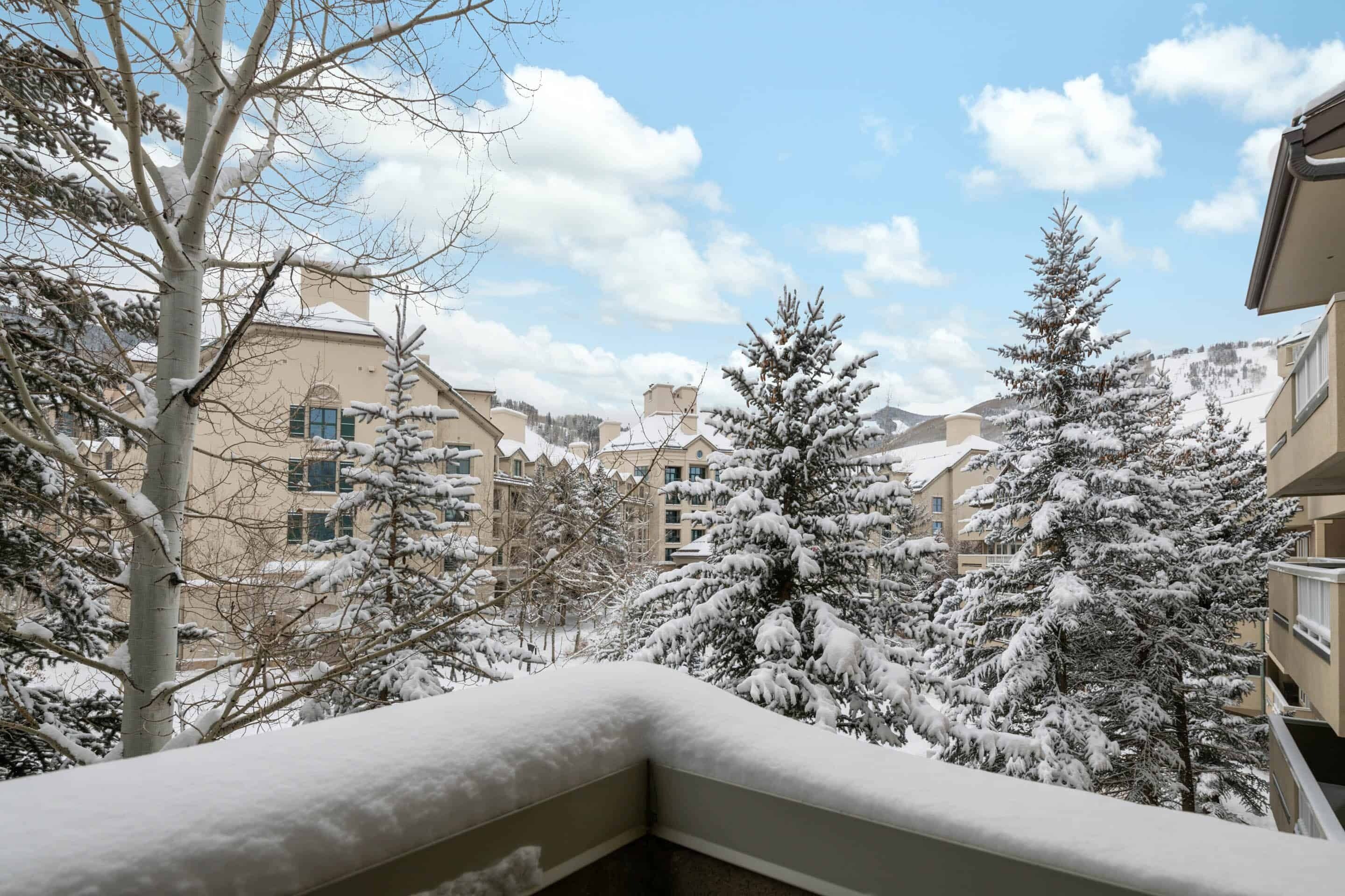A snowy residential area with multi-story buildings and snow-covered trees.