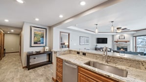A modern kitchen with granite countertops, a dishwasher, and a large island with a sink.