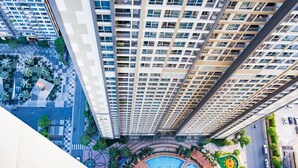 A high-rise building with multiple balconies, a swimming pool, and a landscaped courtyard. - Luxury Landmark - Linh's Apartment (Ho Chi Minh City)