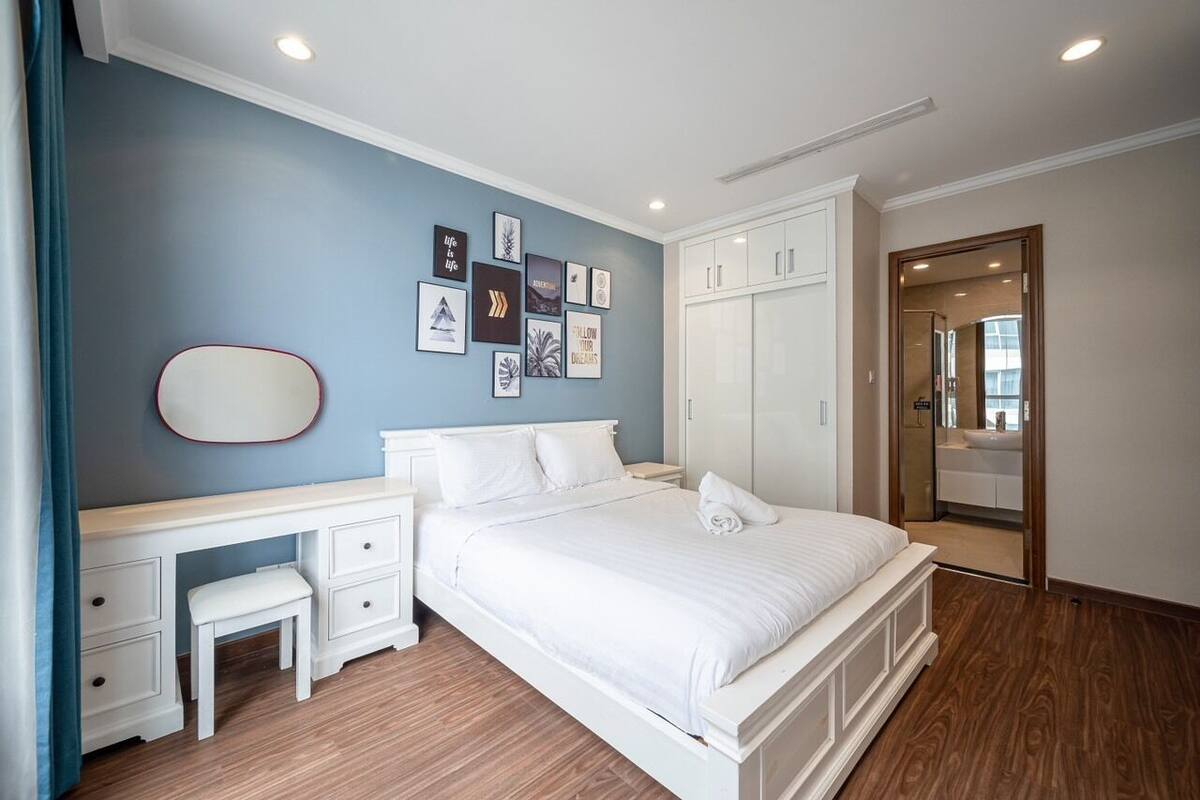 A bedroom with a bed, a desk, a chair, and a wardrobe.