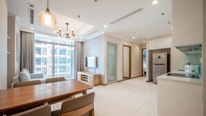 A modern kitchen with a dining area, a built-in oven, and a refrigerator. - Luxury Landmark - Linh's Apartment (Ho Chi Minh City)