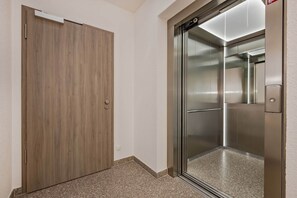 A modern elevator with a metallic finish and a glass door. - Hochwertiges Appartement in Ruhiger Lage, mit Terrasse, Kostenfreier Sauna und S (Zirchow)