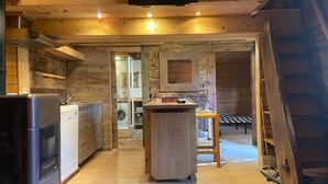 Een moderne keuken met houten wanden, een centraal eiland en een ingebouwde oven.