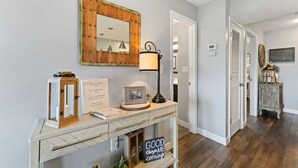 A hallway with a console table, a mirror, a lamp, and a sign that reads "GOOD things are coming." - Cozy Branson Condo, +Free Tickets + Walk-In available (Reeds Spring)