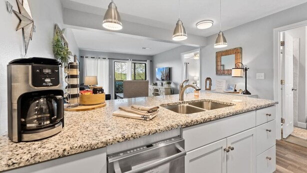 A modern kitchen with granite countertops, stainless steel appliances, and pendant lighting. - Cozy Branson Condo, +Free Tickets + Walk-In available (Reeds Spring)