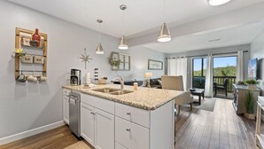 A modern kitchen with granite countertops, white cabinetry, and pendant lighting. - Cozy Branson Condo, +Free Tickets + Walk-In available (Reeds Spring)