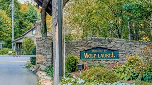 Un mur de pierres sur lequel est apposée une plaque portant l’inscription : « Bienvenue à Wolf Laurel. »