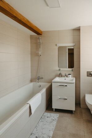 Un baño moderno con bañera, lavabo e inodoro.