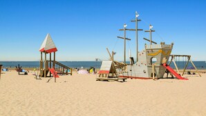 A beach with a lifeguard tower and a small pavilion.