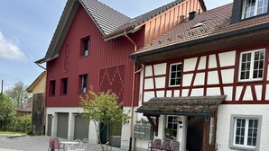 A traditional half-timbered building with a red facade and a white timber frame.