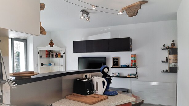 A modern kitchen with a gas stove, a coffee maker, and a TV. - Cozy 4-Person Apartment Steps from Beach, BBQ, WiFi & Parking (Capbreton)