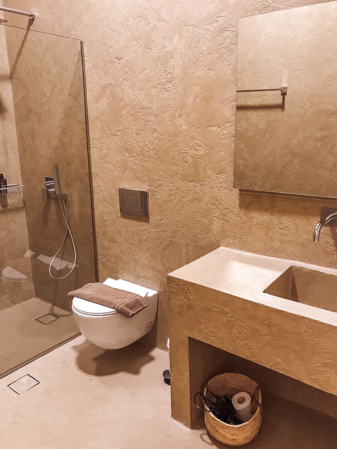 A bathroom with a toilet, sink, and shower.