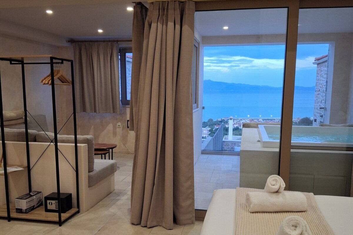 Une chambre d’hôtel avec un lit, un coin salon et une vue sur la mer.