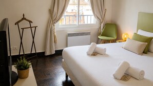 A hotel room with a bed, a chair, a TV, a plant, and a window with curtains. - URBAN AP4346 By Riviera Holiday Homes (Niza)