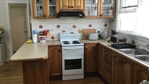 Eine Küche mit Holzschränken, einem weißen Herd, einem Toaster und einem Spülbecken.