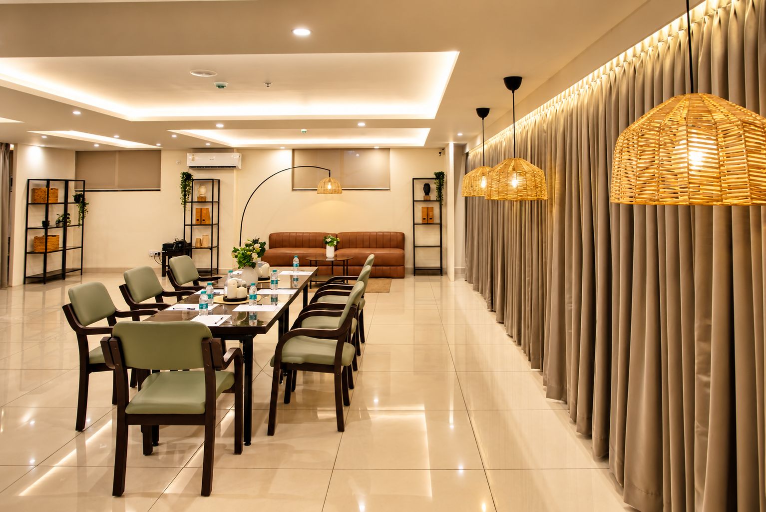 A modern dining area with a long table, chairs, and a sofa.