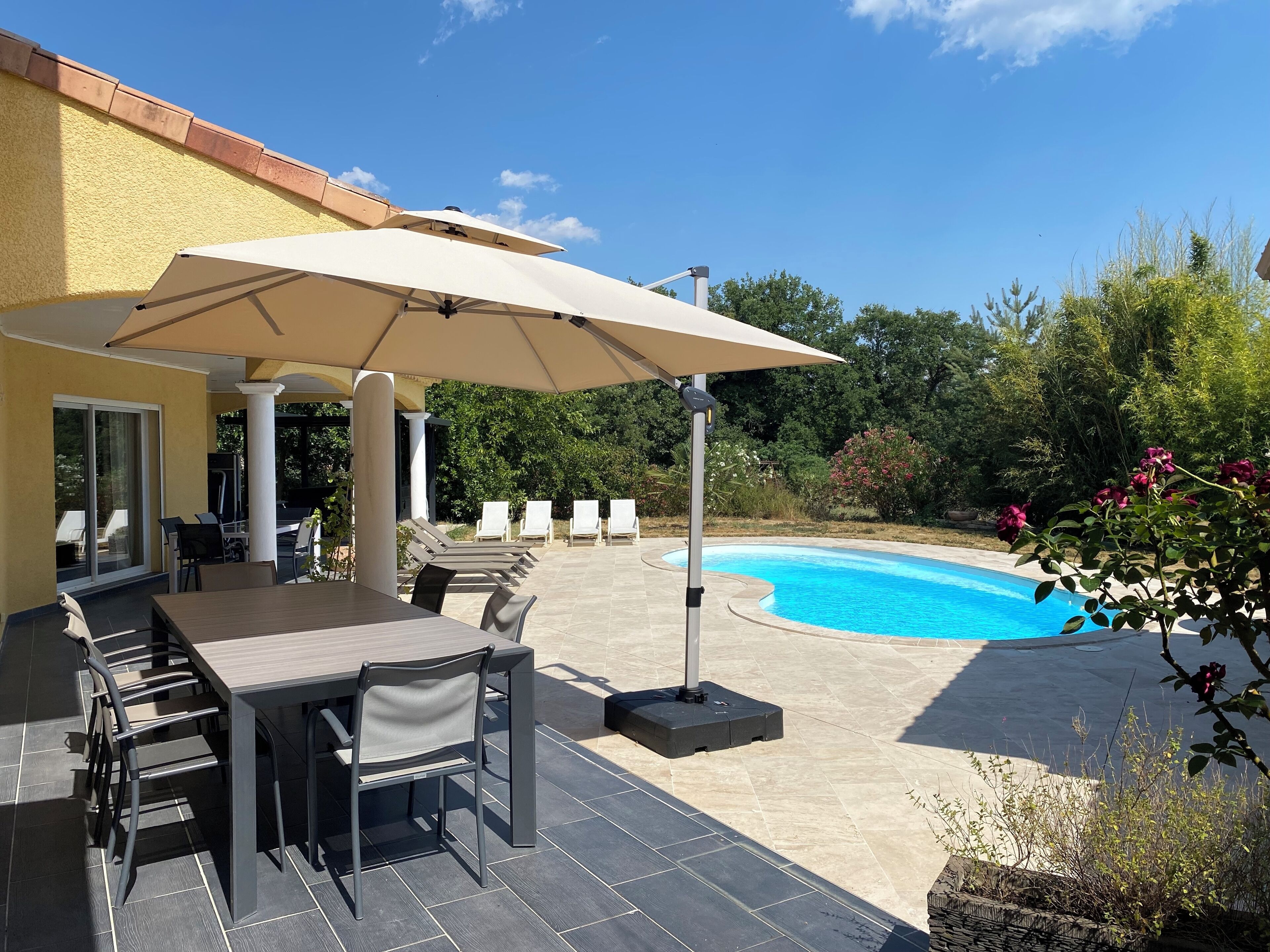 A patio area with a pool, outdoor seating, and a covered table.
