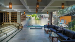 A modern interior with a staircase leading to an upper level, a seating area with a sofa and coffee table, and large windows offering a view of the outside. - Olive County Manali (Manali)