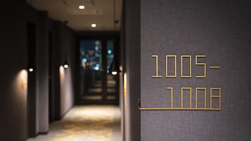 A hallway with a textured wall and a sign displaying '1005-1008'.
