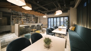 Et moderne interiør med barområde, siddepladser og et stort vindue med udsigt.