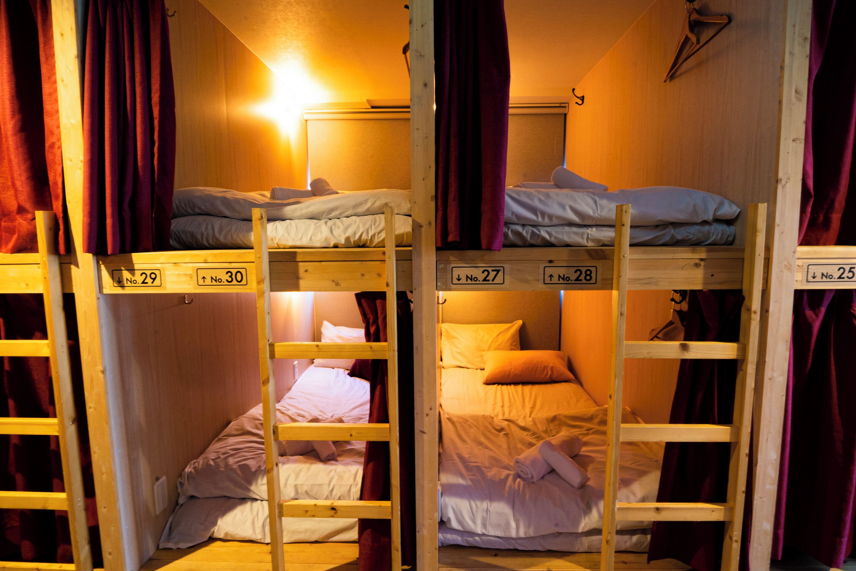 Bunk beds in a room with wooden walls and purple curtains.