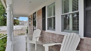 A covered porch with two Adirondack chairs and a small table. - Stroll Chatham's Historic Downtown / Shops, Dining, Galleries, Etc. (Chatham)