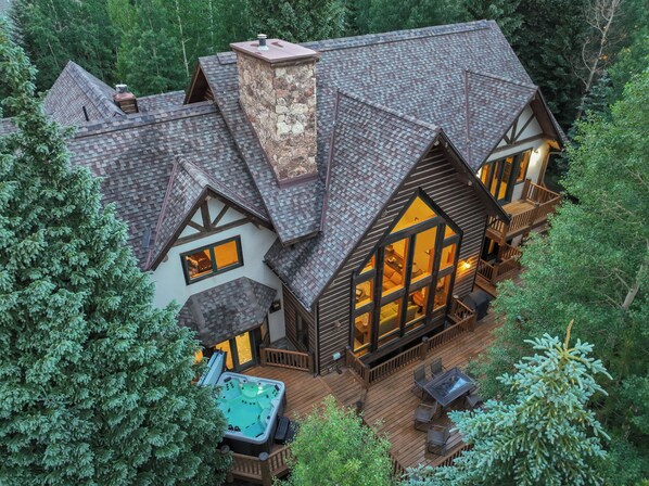 A large house with a spacious deck, a hot tub, and a large window overlooking the deck. - Short walk to downtown, shuttle, hot tub, game room, walk to two parks! (Breckenridge)