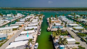 A marina with boats, a clear sky, and a view of the ocean. - Captain's Quarters 3bed/2bath mobile home with dockage (Marathon)