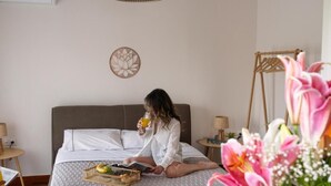 A bed with a basket of fruits and a book, a wall decor, and a hanging light fixture. - Visum Acropol ,3BR - Private Terrace-Jacuzzi - Amazing View (Athens)