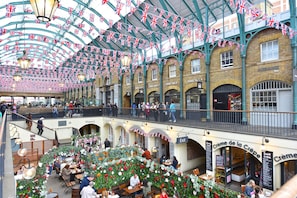 Explore a vibrant market with multiple levels, shops, and eateries, including a Shake Shack and Creme de la Creme bakery.