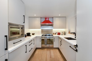 Enjoy cooking in this well-lit kitchen with a stainless steel range, oven, and modern sink.