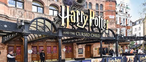 A theater entrance with a sign for "Harry Potter and the Cursed Child".